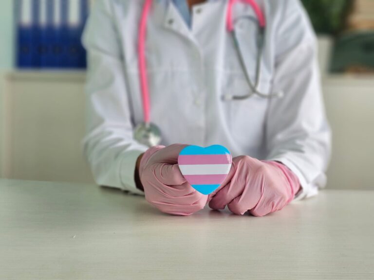 Doctor holding a heart-shaped transgender symbol