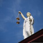 Lady Justice statue against a blue sky