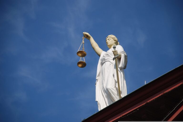 Lady Justice statue against a blue sky