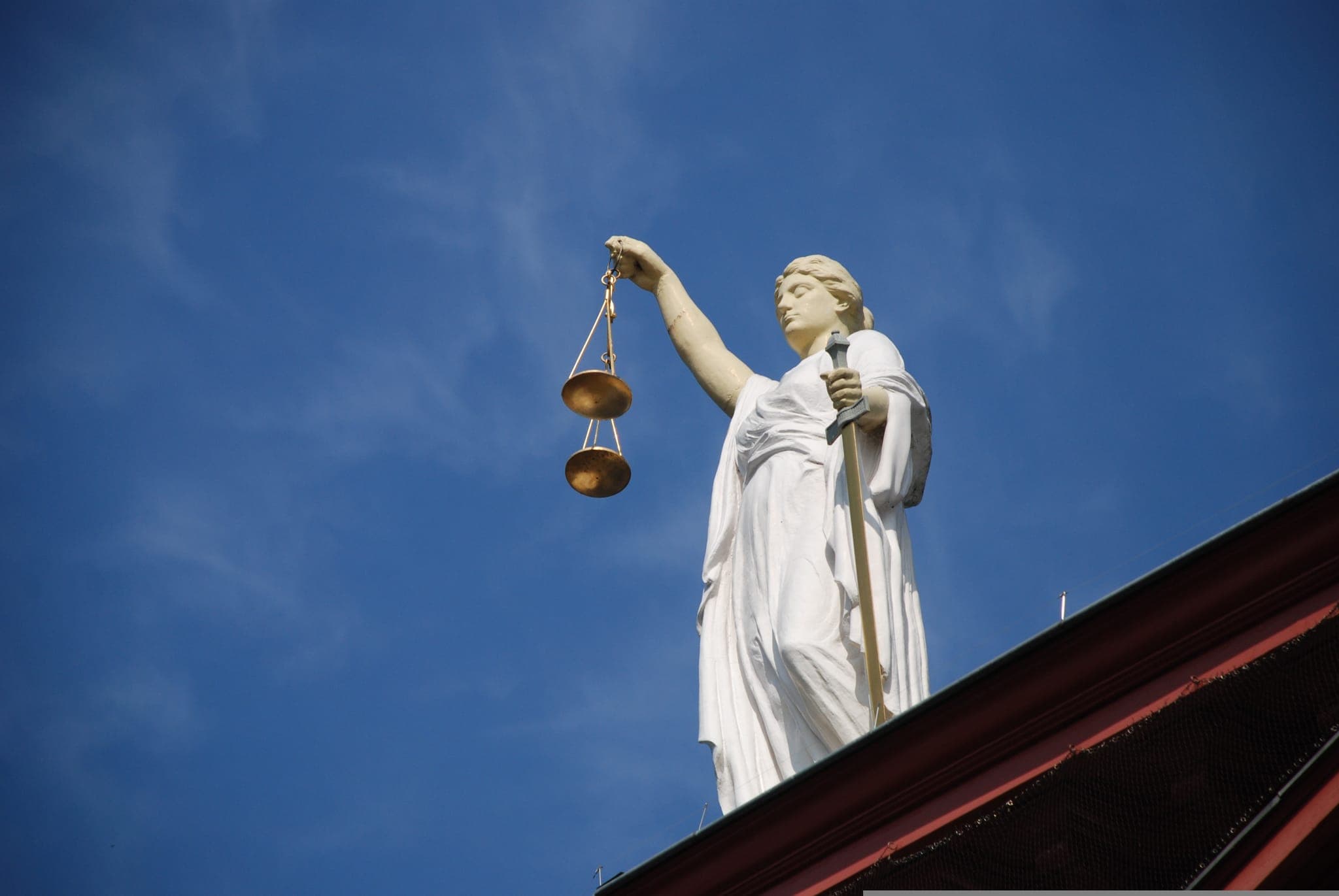 Lady Justice statue against a blue sky