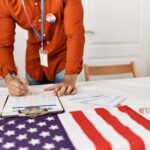 Election worker completing voter registration paperwork beside an American flag